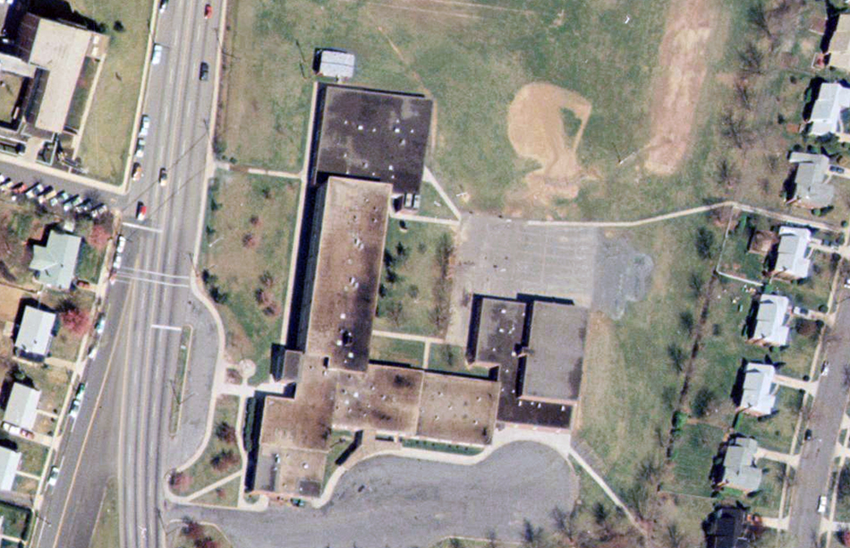 Color aerial photograph of Lynbrook Elementary School taken in 1976. The building is seen from directly overhead. The additions to the original structure are readily apparent.  