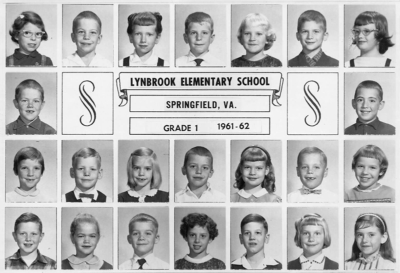 Photograph of a Memory Book page from the 1961 to 1962 school year. The page has black and white head-and-shoulders portraits of students arranged in four rows. At the center of the second row is a box with text that reads Lynbrook Elementary School, Springfield, Virginia, Grade 1, 1961-62. 23 children are pictured.