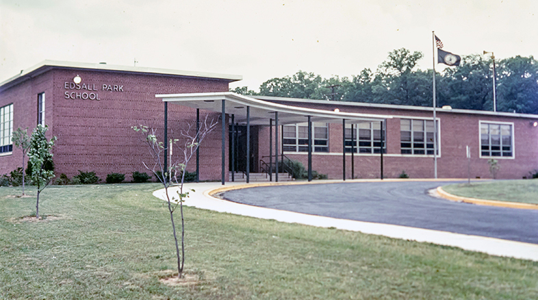 Color 35 millimeter slide photograph of the front exterior of Edsall Park Elementary School. The picture is believed to date from around 1980. The original main entrance of the building is shown.