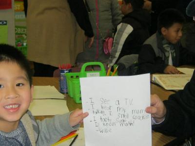 child shows his writing at literacy night